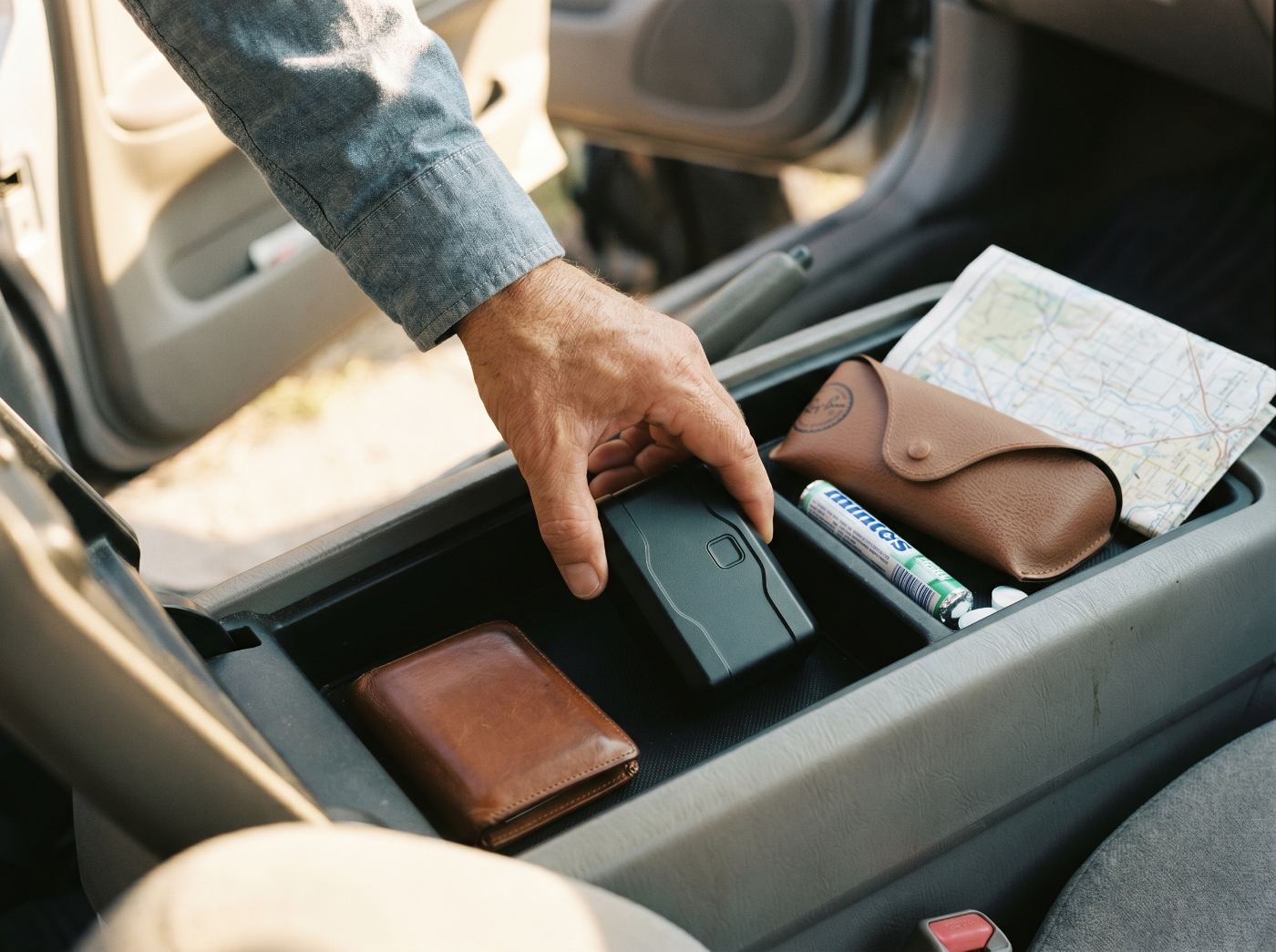 Hand placing the Orb in a car's center console